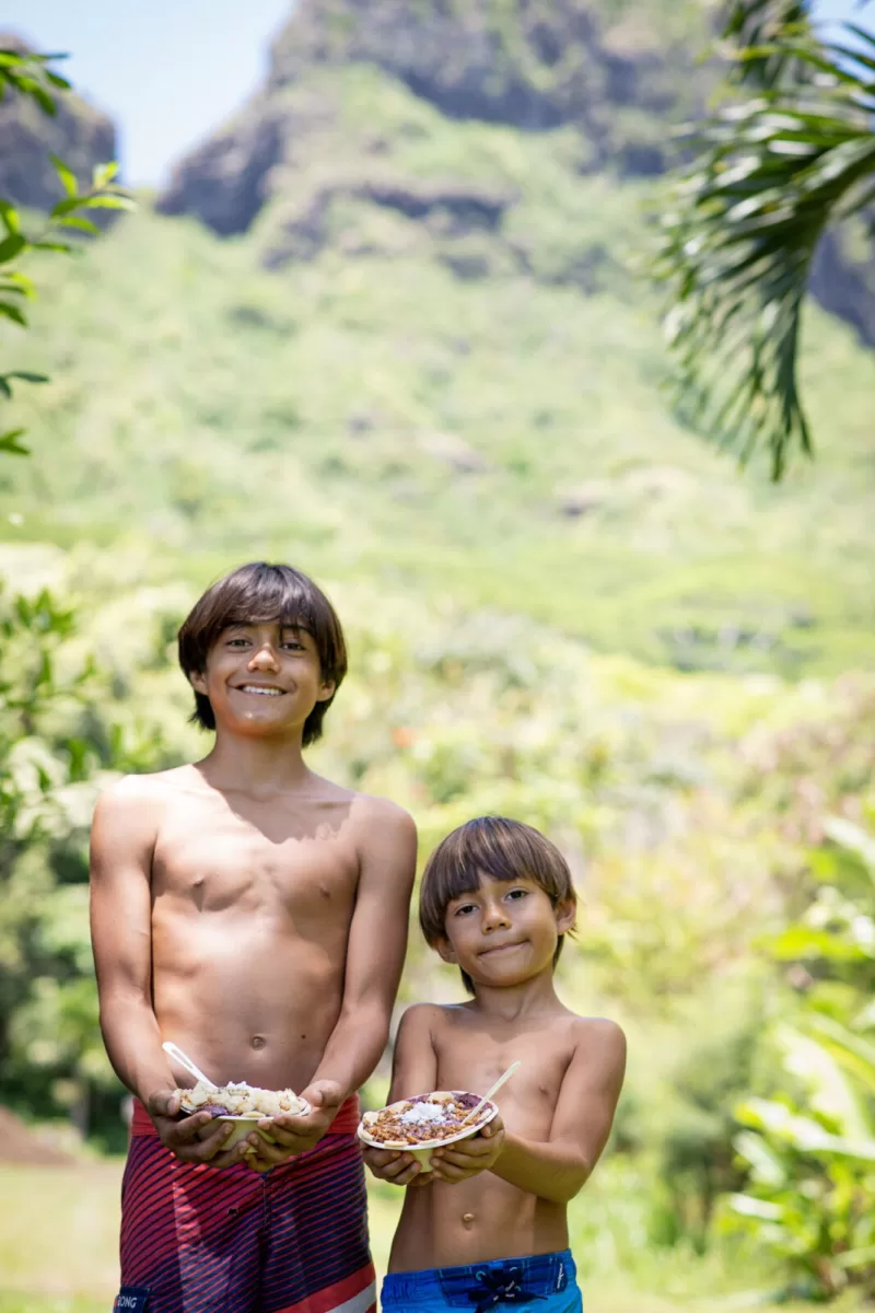 two kids holding fruits