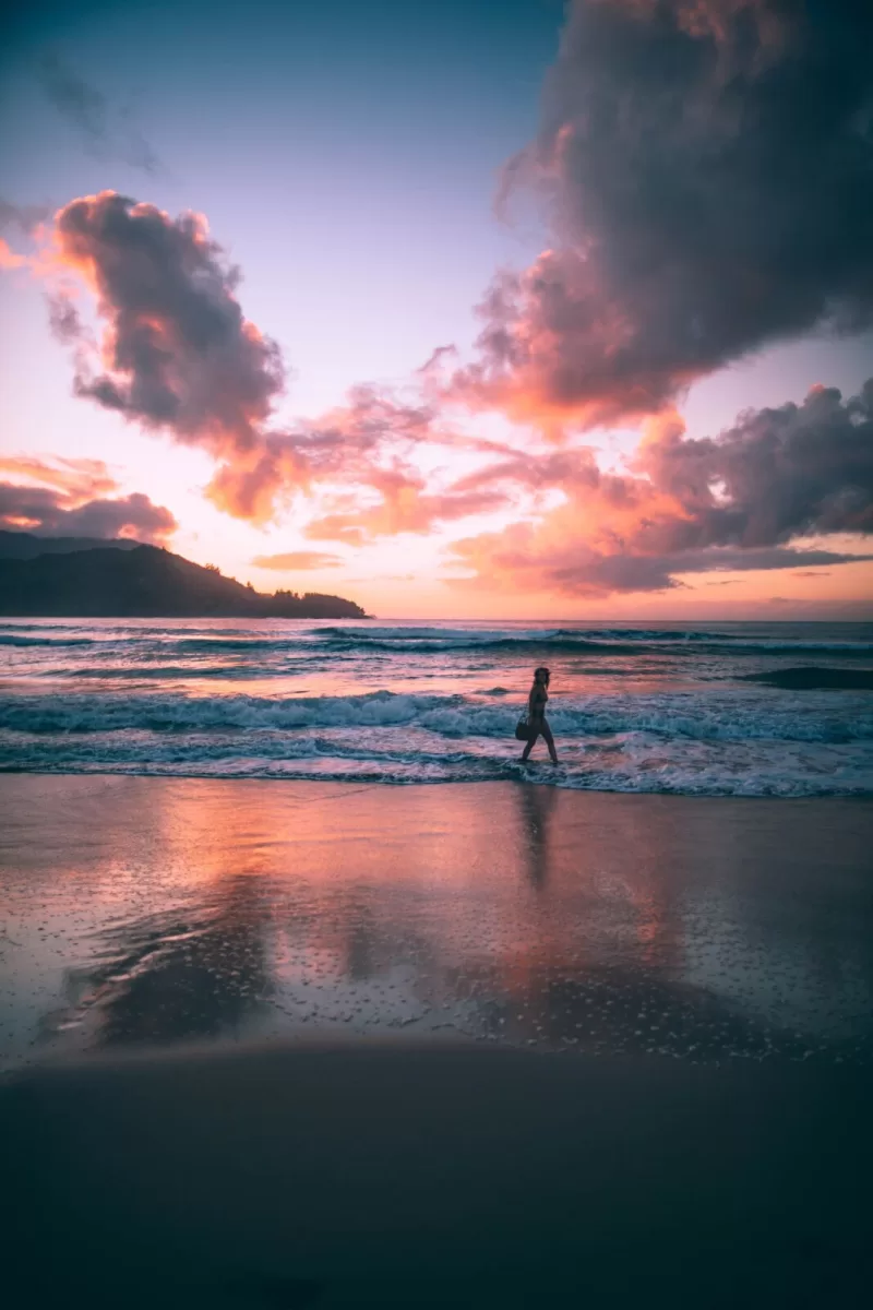 woman walking on the beach at sunset