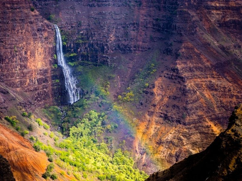 waipoo falls view in kauai with rainbow