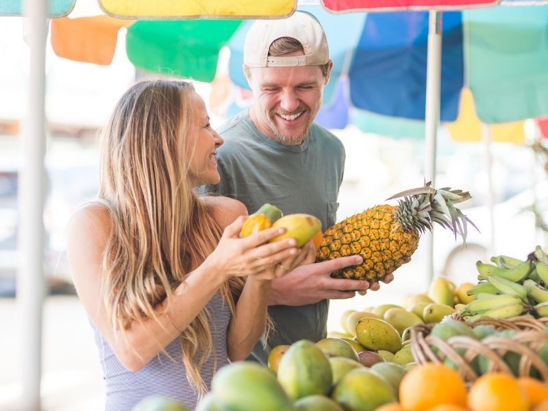 man and woman shopping farmers market in kauai