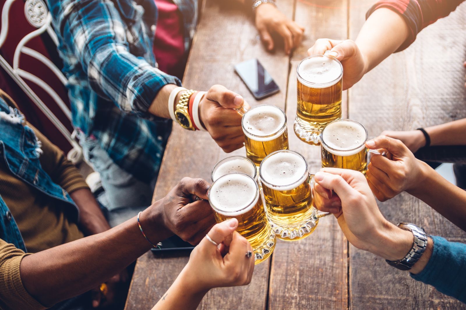 group of friends clinking their beers together at kauai brewery